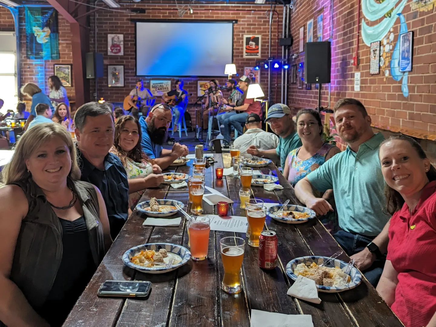 RPS team members and their spouses at a concert event, sitting at a table in front of the stage